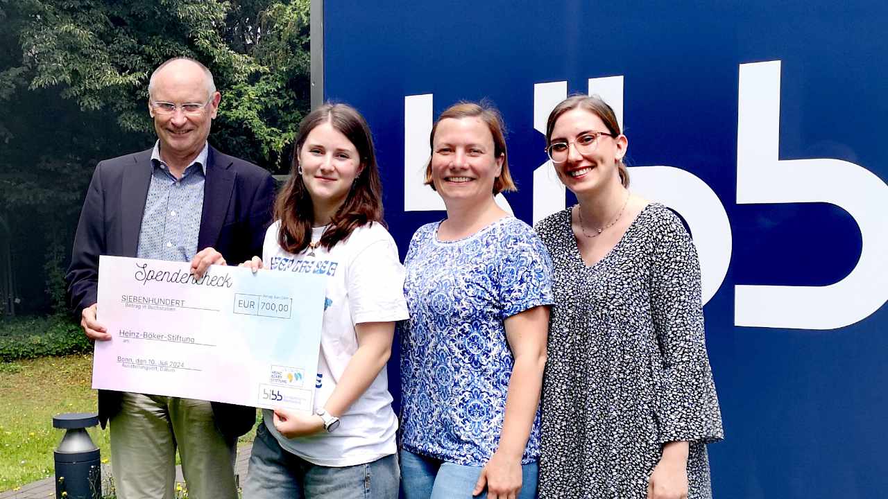 4 people in front of BIBB-Logo